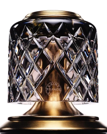 Close-up of a crystal table lamp featuring a diamond pattern and gold-colored accents on a white background, highlighting its design.