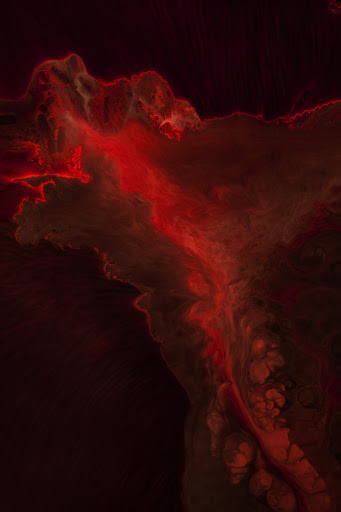 Abstract red smoke-like pattern with a dark background, creating a sense of depth and ethereal quality in a vertical orientation.