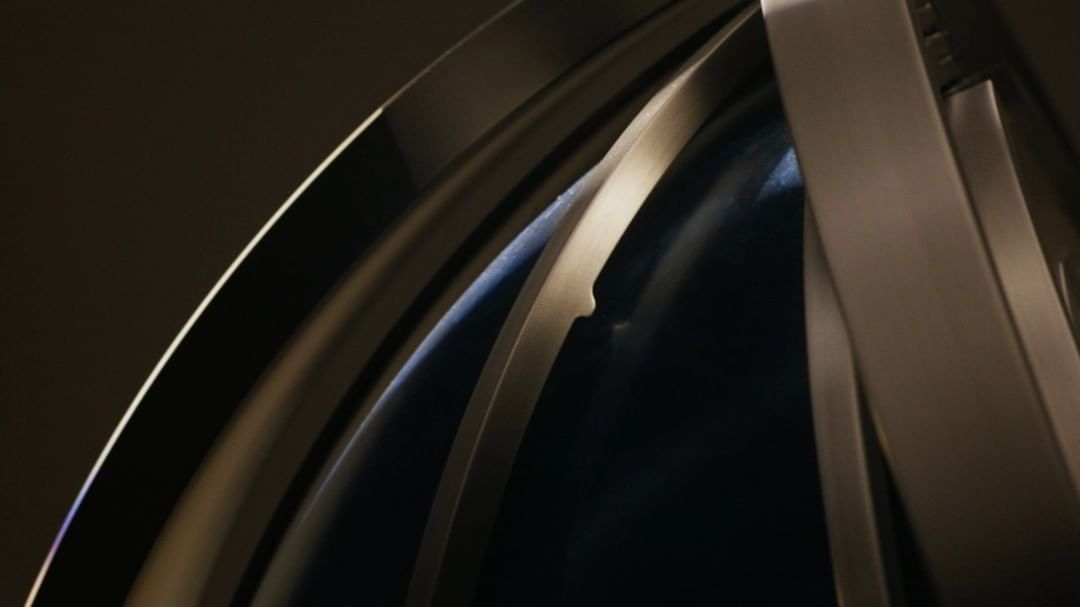 Close-up shot of a modern silver or gray metallic structure featuring curved designs and soft lighting, possibly part of an architectural element.