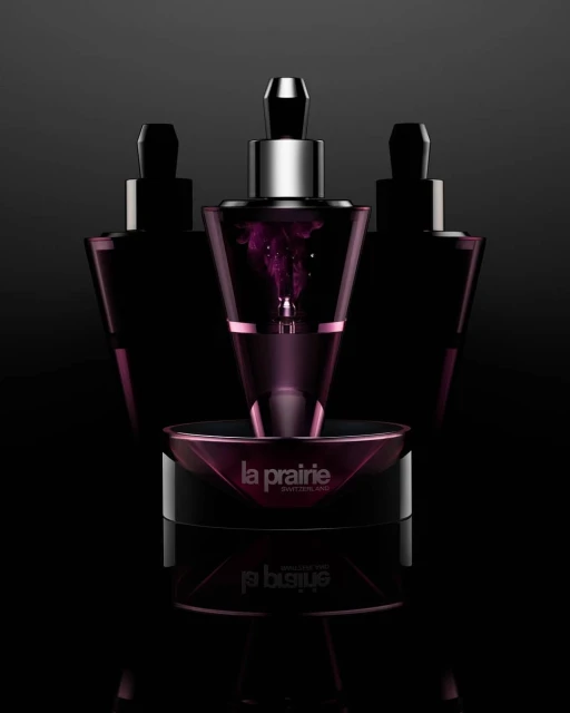 Three La Prairie skincare products sit in a close-up studio shot with a dark background and strong lighting to highlight the product details.