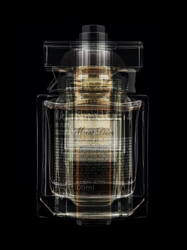 Luxury perfume bottle featuring both Chanel and Miss Dior branding with overlapping translucent glass design on a stark black backdrop.