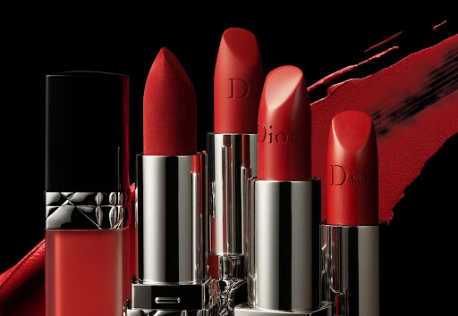Close-up studio shot of red Dior lipsticks in silver tubes, showcasing the elegant design against a stark black background.