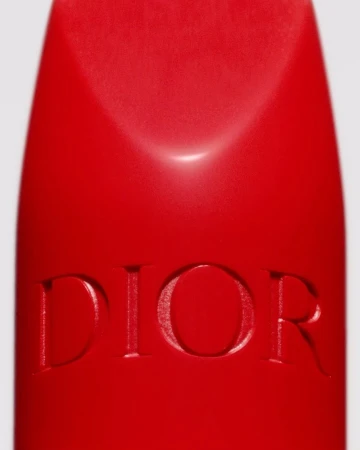 Extreme macro close-up of a red lipstick bullet showing embossed Dior lettering against a white background.