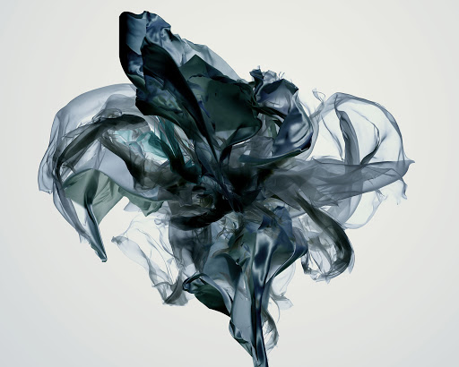 Abstract image featuring flowing, translucent fabric in shades of teal and grey, creating a dynamic and airy composition against a white background.