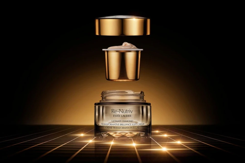 Estee Lauder Re-Nutriv Ultimate Diamond Transformative Brilliance Soft Creme jar with golden lid and insert, displayed on illuminated grid.