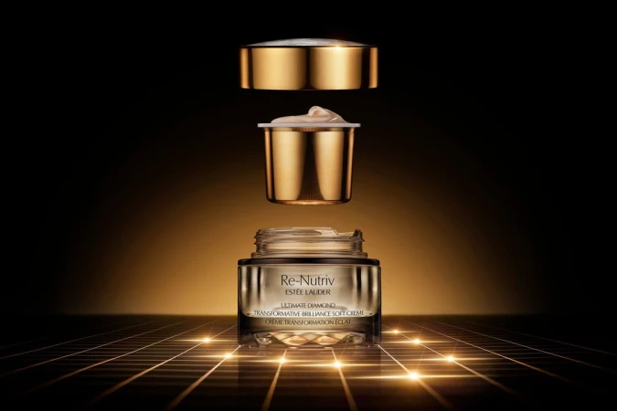 Estee Lauder Re-Nutriv Ultimate Diamond Transformative Brilliance Soft Creme jar with golden lid and insert, displayed on illuminated grid.