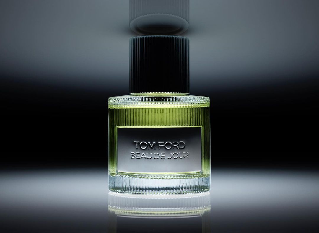Bottle of Tom Ford Beau de Jour perfume on a reflective surface, showcasing a sleek design and highlighting the product details.