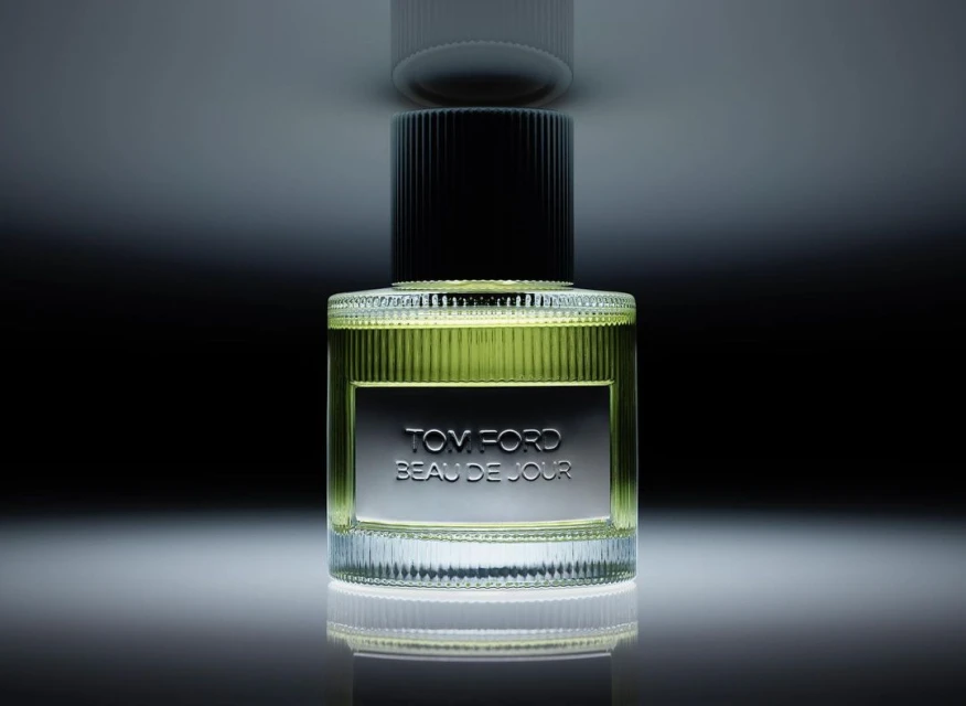 Bottle of Tom Ford Beau de Jour perfume on a reflective surface, showcasing a sleek design and highlighting the product details.