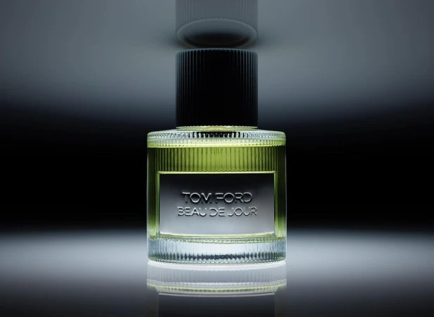 Bottle of Tom Ford Beau de Jour perfume on a reflective surface, showcasing a sleek design and highlighting the product details.