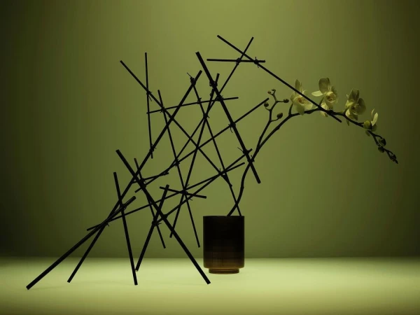 Still life of an off-white orchid branch in a brown vase, with a criss-cross pattern of dark sticks, against a graduated green backdrop.