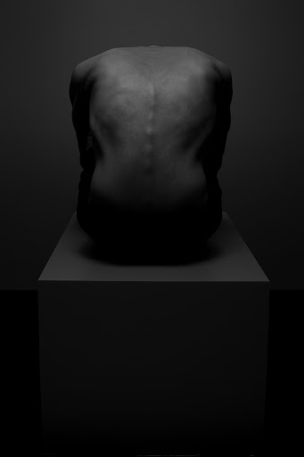 Monochrome portrait from behind of a person crouched on a block in deep shadow