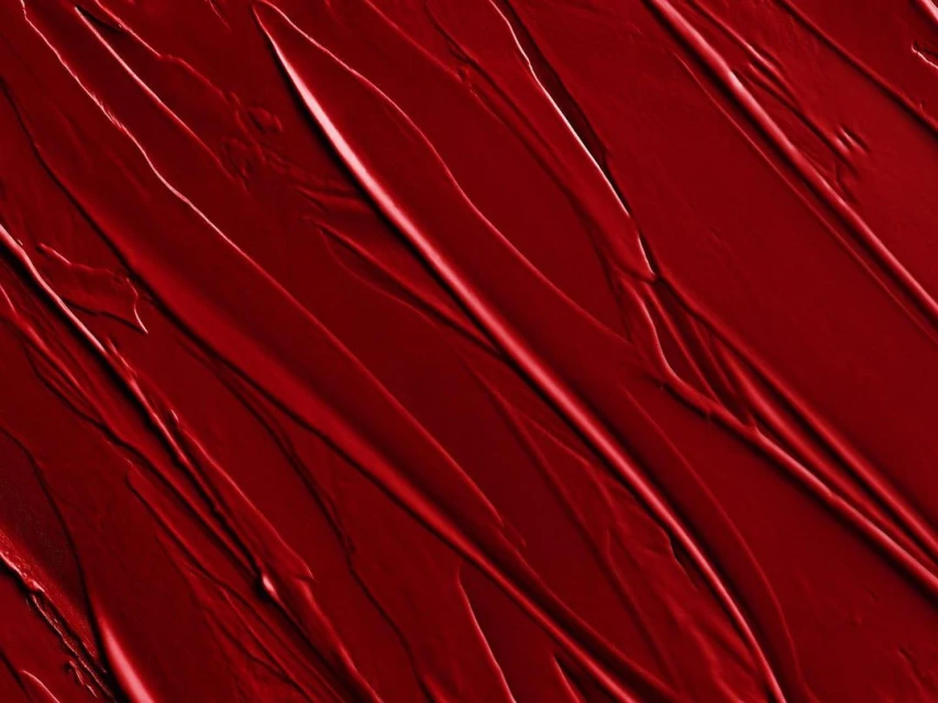 Abstract image of red textured paint strokes, creating a dynamic pattern with varying shades and highlights, ideal for backgrounds.