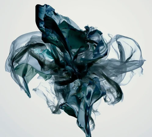 Dynamic composition of suspended dark blue and green sheer fabric swirling against a white background