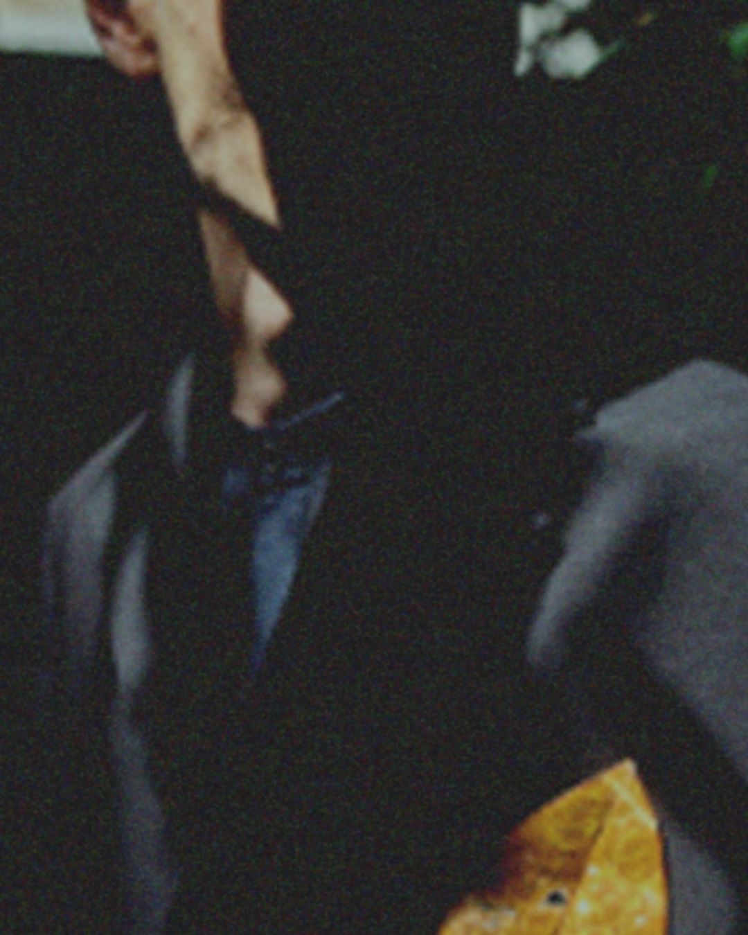 Close-up portrait of a man in a dark suit jacket photographed by Nicolas Kern with grainy film texture.