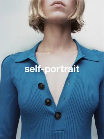 Close-up portrait of a woman wearing a bright blue ribbed polo top with dark buttons against a plain white background.