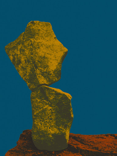 Two stacked rocks with a golden hue, balanced on a base rock against a dark blue sky in a minimalist abstract composition.