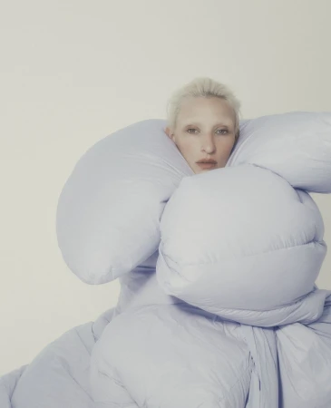 Model with bleached hair wrapped tightly inside voluminous pale blue padded outerwear