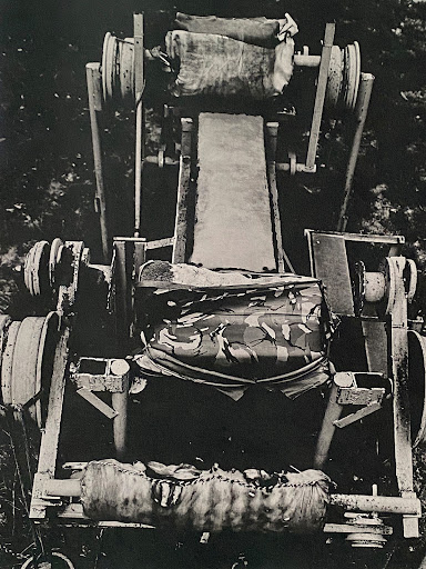 Monochrome image of an aged, weathered machine in outdoor setting shows signs of decay and abandonment.