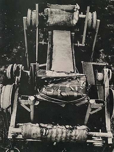 Monochrome image of an aged, weathered machine in outdoor setting shows signs of decay and abandonment.