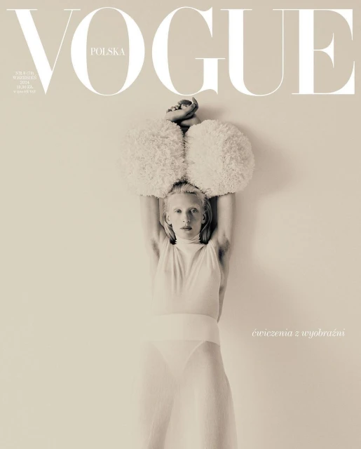 Vogue Polska cover featuring a person in a white bodysuit with large, fluffy shoulder pieces, with the magazine's logo at the top.