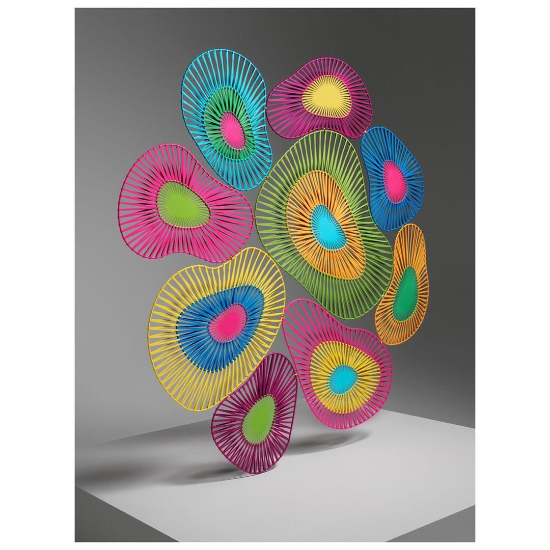 Colorful abstract wall art installation featuring geometric shapes and vibrant neon concentric circles on a white and gray background.