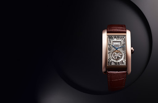 Elegant close-up studio shot of a rose gold Cartier Tank watch with a brown leather band against a dark, contrasting background.