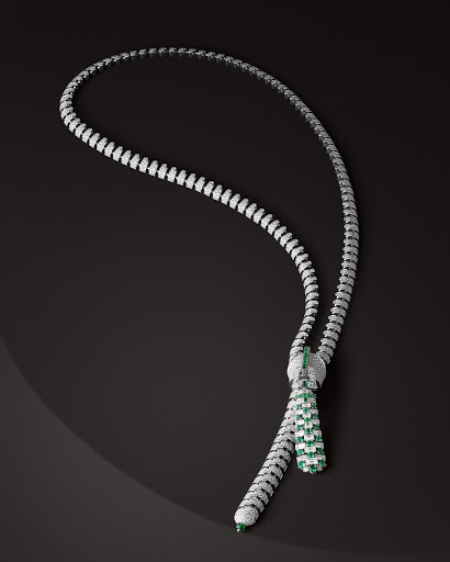 Elegant necklace with white and green gemstones, set against a dark background, highlighting its intricate design and luxurious appearance.