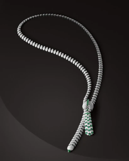 Elegant necklace with white and green gemstones, set against a dark background, highlighting its intricate design and luxurious appearance.