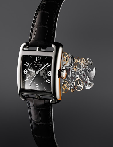 Elegant Hermès watch with black leather strap, silver case, black dial, and visible watch mechanism on a seamless dark gradient background.