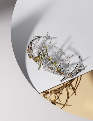 Abstract jewelry artwork featuring a silver geometric design with gemstones, set against a gradient white and gold reflective background.