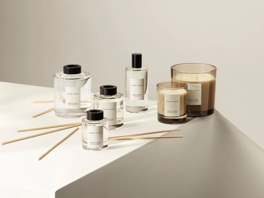 Zara Home fragrance diffusers and candles in clear glass containers arranged on a light gray surface with neutral studio background.