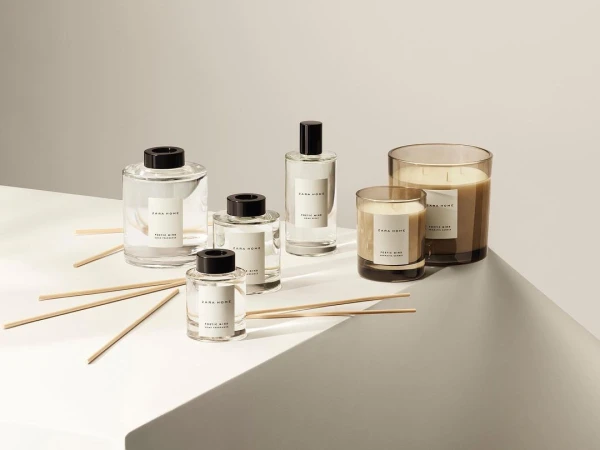 Zara Home fragrance diffusers and candles in clear glass containers arranged on a light gray surface with neutral studio background.