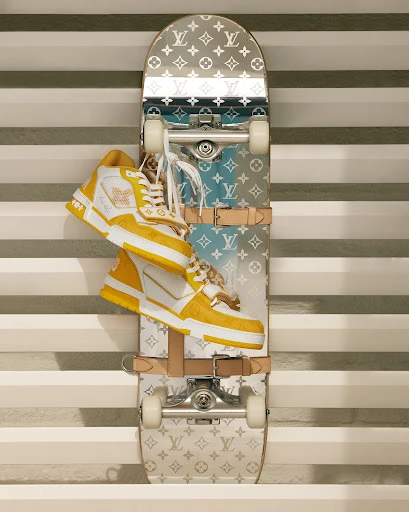 Elevated view of a skateboard with Louis Vuitton monogram design and yellow and white high-top sneakers stacked on top of it.