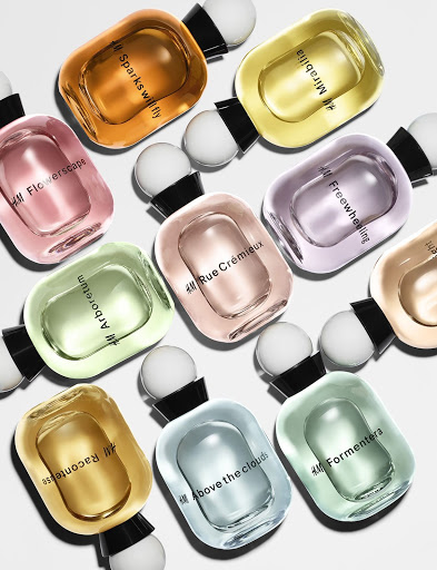 Collection of H&M perfume bottles in various colors and scents including Mirabilia, Sparks Will Fly, and Arboretum on white.