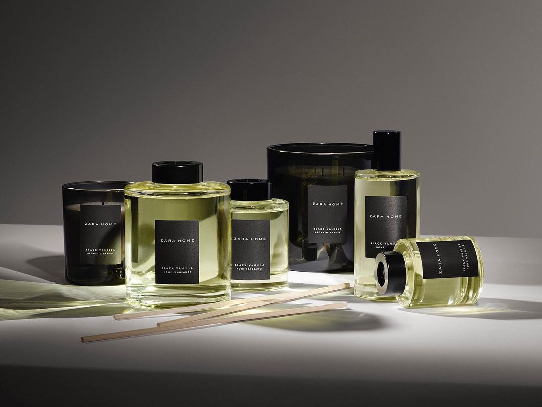 Zara Home fragrance collection featuring candles, reed diffusers, and sprays in glass containers with minimalist black labels and wooden sticks.