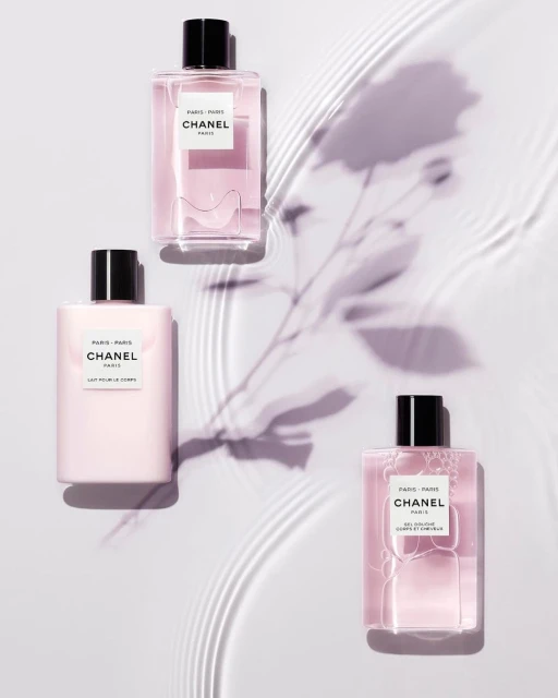 Three bottles of Chanel Paris-Paris fragrance are arranged on a pale background, casting a soft shadow, accentuating their elegant design.