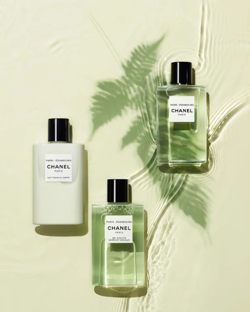 Three Chanel Paris Les Eaux De Chanel bottles are arranged on a light background with a fern shadow and water ripple effect.