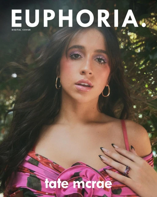 Close-up of Tate McRae on Euphoria digital cover, wearing a pink floral top with gold hoop earrings, against a green leafy backdrop.