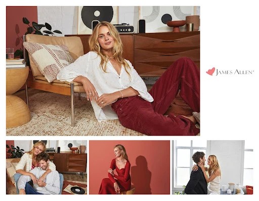 Blonde woman poses indoors wearing a white blouse and maroon pants, seated next to a tan chair and mid-century modern cabinet.