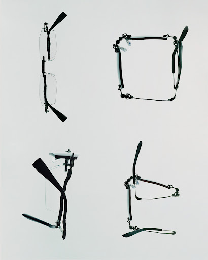 Four pairs of clear eyeglass frames with black temples are displayed on a solid white background in a studio-like setting.