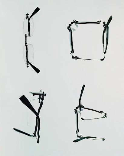Four pairs of clear eyeglass frames with black temples are displayed on a solid white background in a studio-like setting.