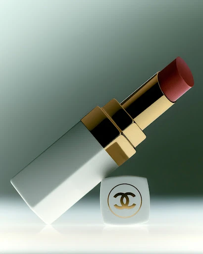 Elegant lipstick tube and logo cap lying on a white surface with diffused background lighting, product shot for beauty and fashion.