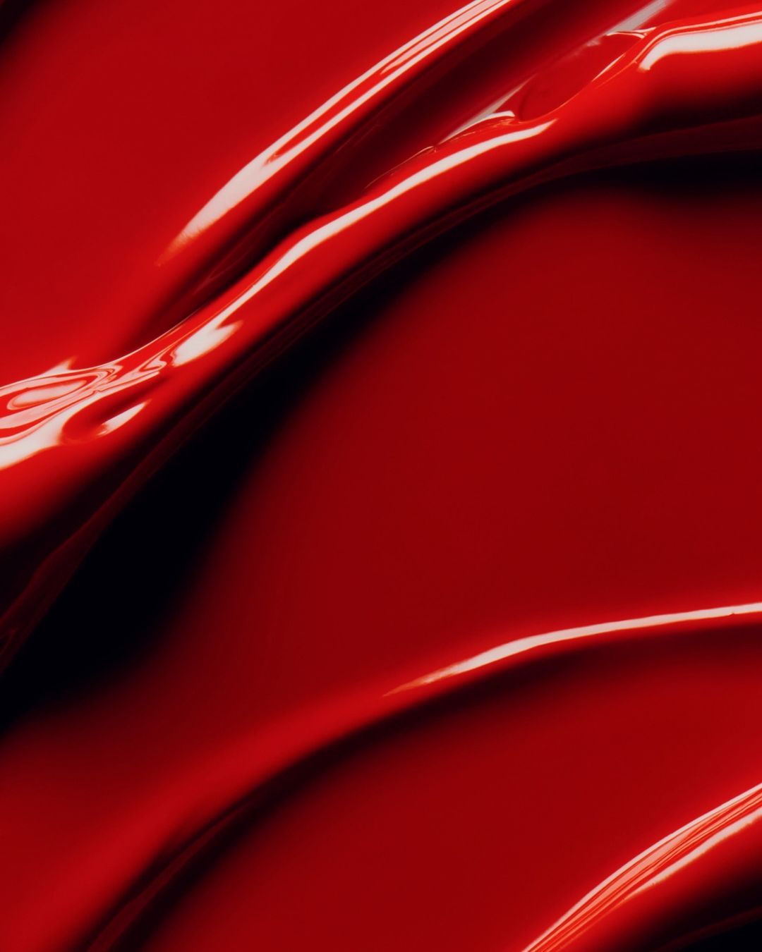 Macro photograph of red liquid creates glossy waves. Perfect for backgrounds, beauty industry, and abstract concepts. High quality studio shot.
