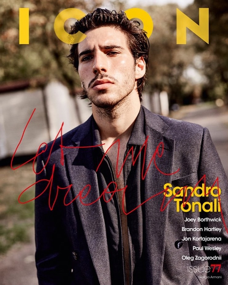 Portrait of Sandro Tonali on the cover of ICON magazine, wearing a dark blazer. He stands outside on a tree-lined street with text overlay.