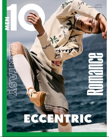 Magazine cover featuring a person in a hoodie and shorts posing outdoors with ocean background and the text "10 Men Fantasy Romance Eccentric".
