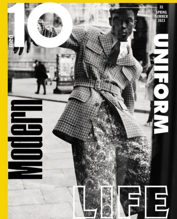 Ten Men magazine cover featuring a model in a checkered coat and patterned pants, posing in an urban setting, with bold typography.
