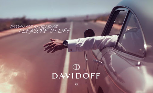 Car commercial featuring an arm extended out of the driver's side window on an open road with the DAVIDOFF logo and slogan visible.
