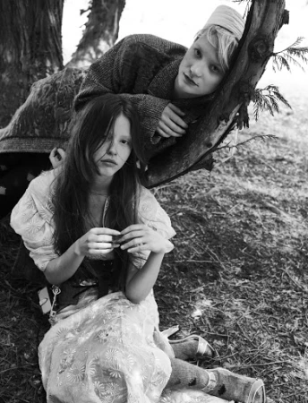 Black and white portrait of two young women outdoors by a tree trunk, photographed by Stefano Galuzzi.