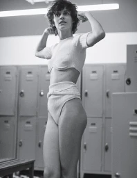 Monochrome portrait of a woman with short dark hair flexing her arms inside a locker room by photographer Stefano Galuzzi