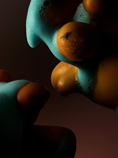 Macro shot of smooth orange objects partially covered in bright blue soapy foam against a dark gradient background.